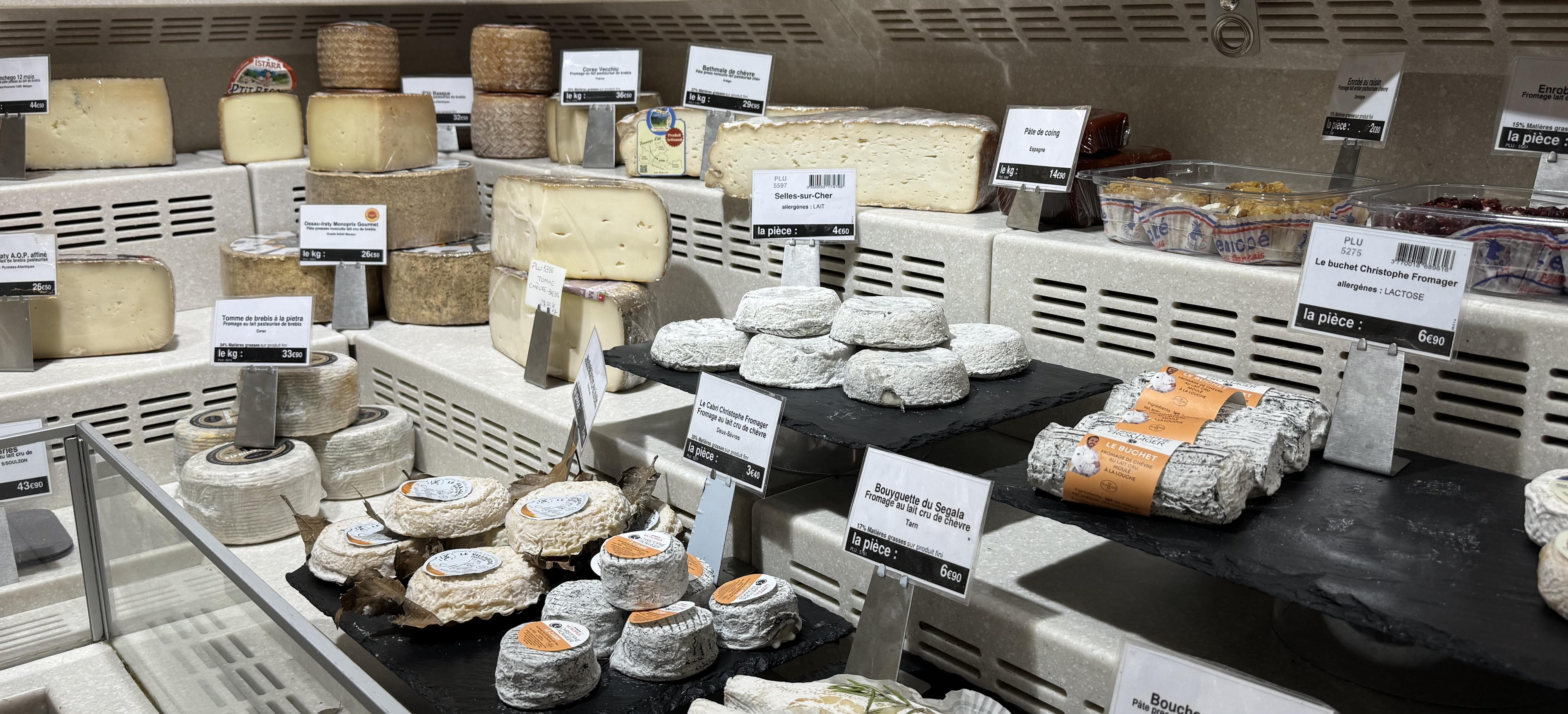 a selection of cheeses in a supermarket. There are a mix of soft and hard cheeses, some are sold as the piece and others you can get slices of