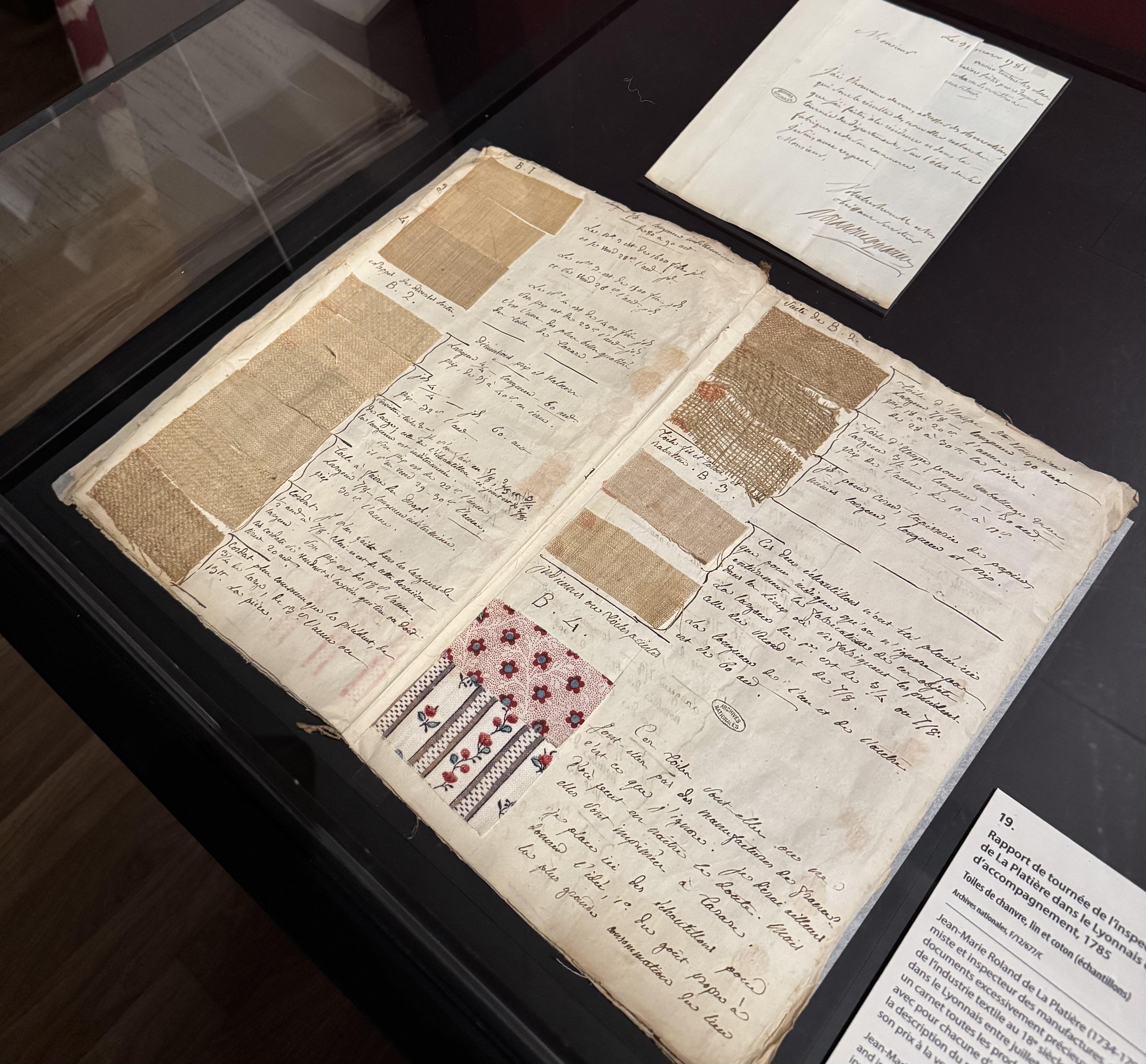 a book with different fabric samples. Next to each sample there's some text in French