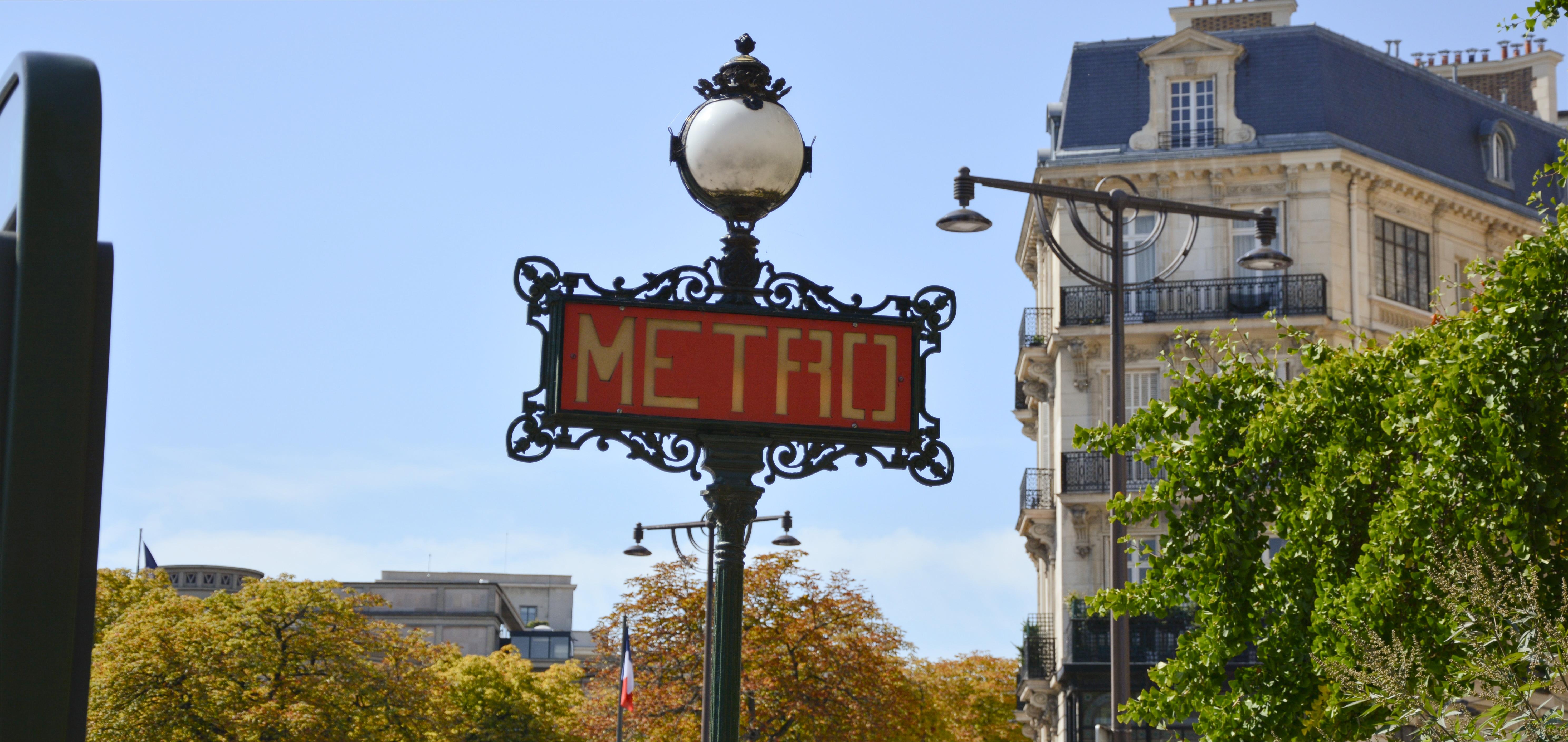 A paris metro sign taken from outside the station. It is red with METRO written in white capital letters.