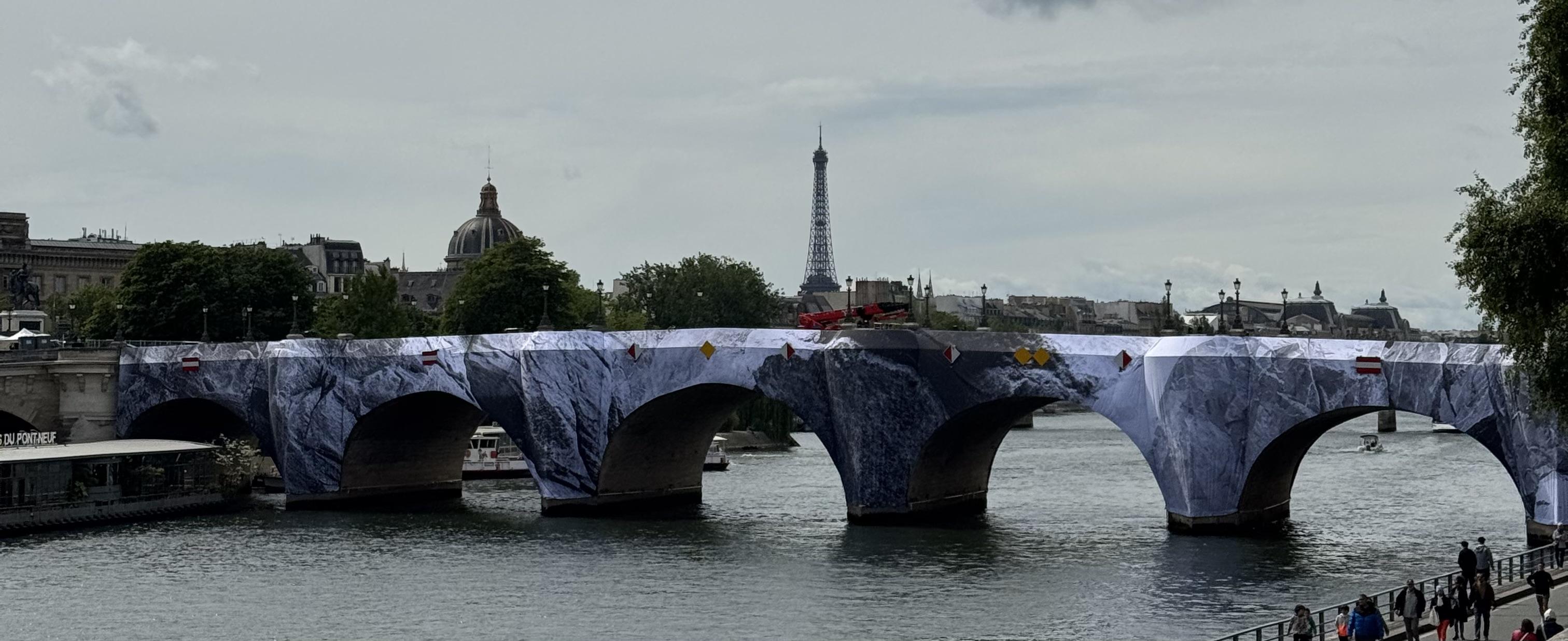 early stages of the constriction. The bridge has been wrapped in a fabric that looks like mountains but no height has been added yet. In the background you can see the Eiffel Tower.