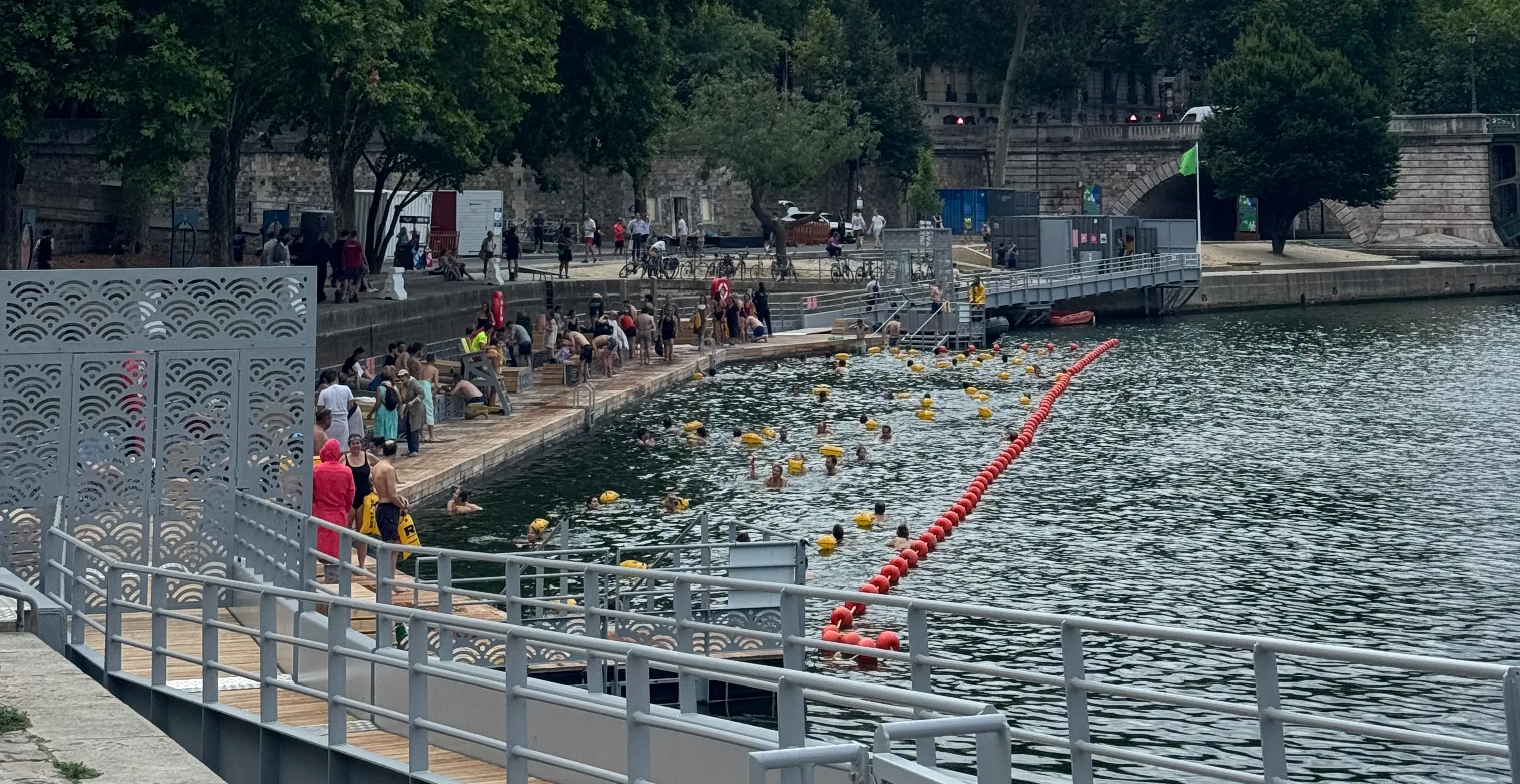 a section of the river where you&#x27;re allowed to swim in. In the water you can see some people, all of them have a yellow float attached to them