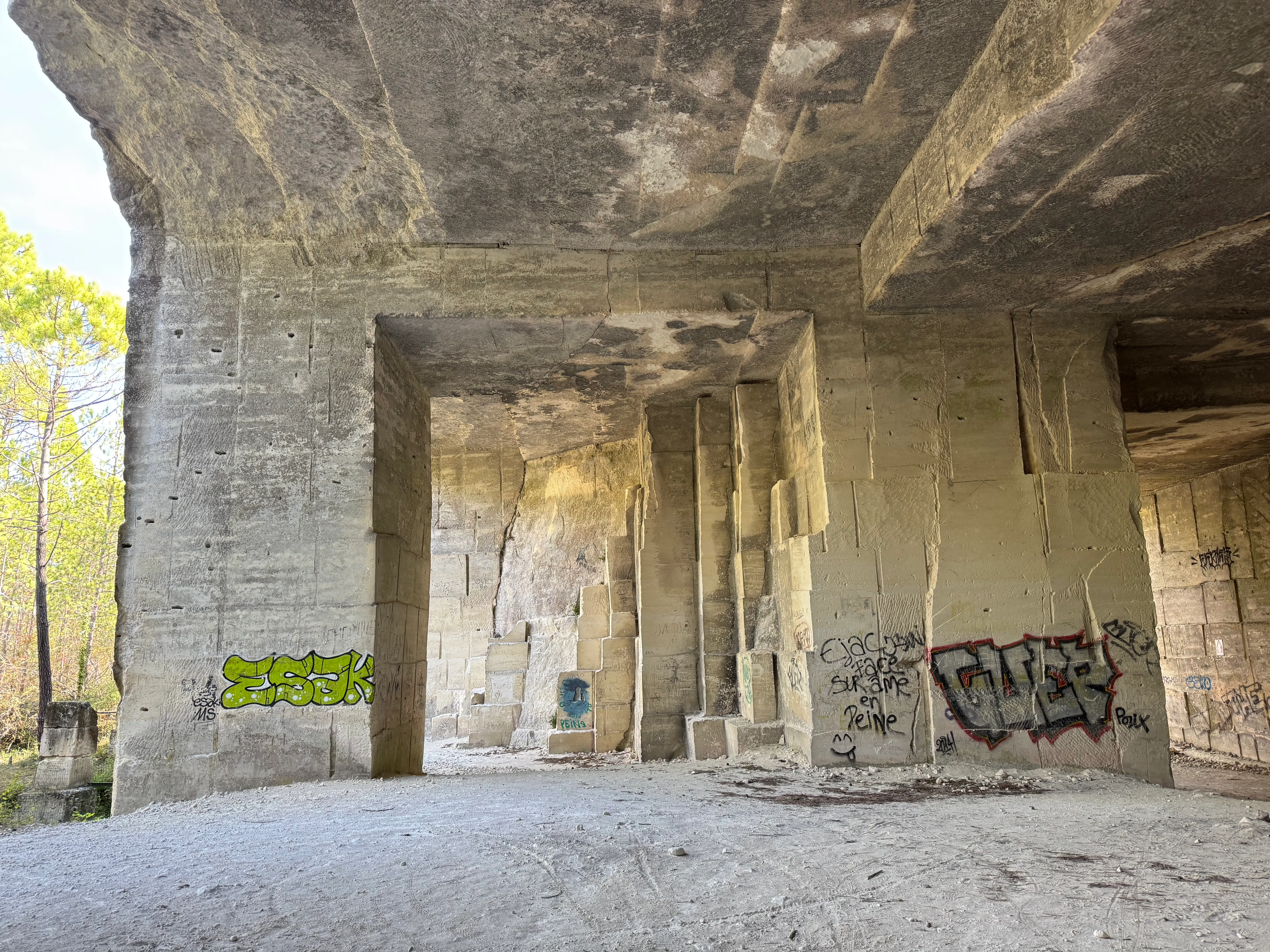 the quarry with trees in the background. Some of the stones have graffiti on them