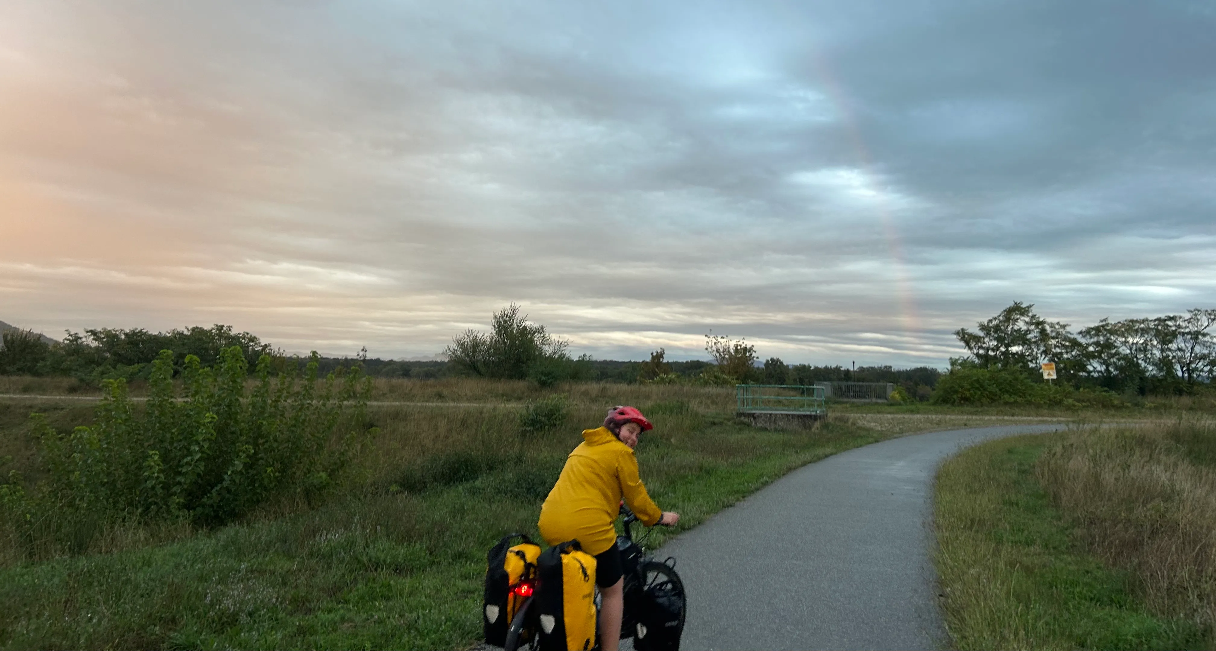 a photo of me cycling, with the sunset and a rainbow